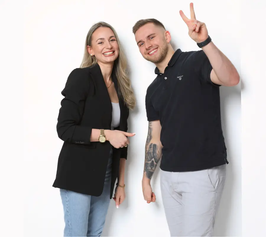 Luca und Alina lächeln freundlich in die Kamera – Luca zeigt das Peace-Zeichen, Alina hält den Daumen hoch.